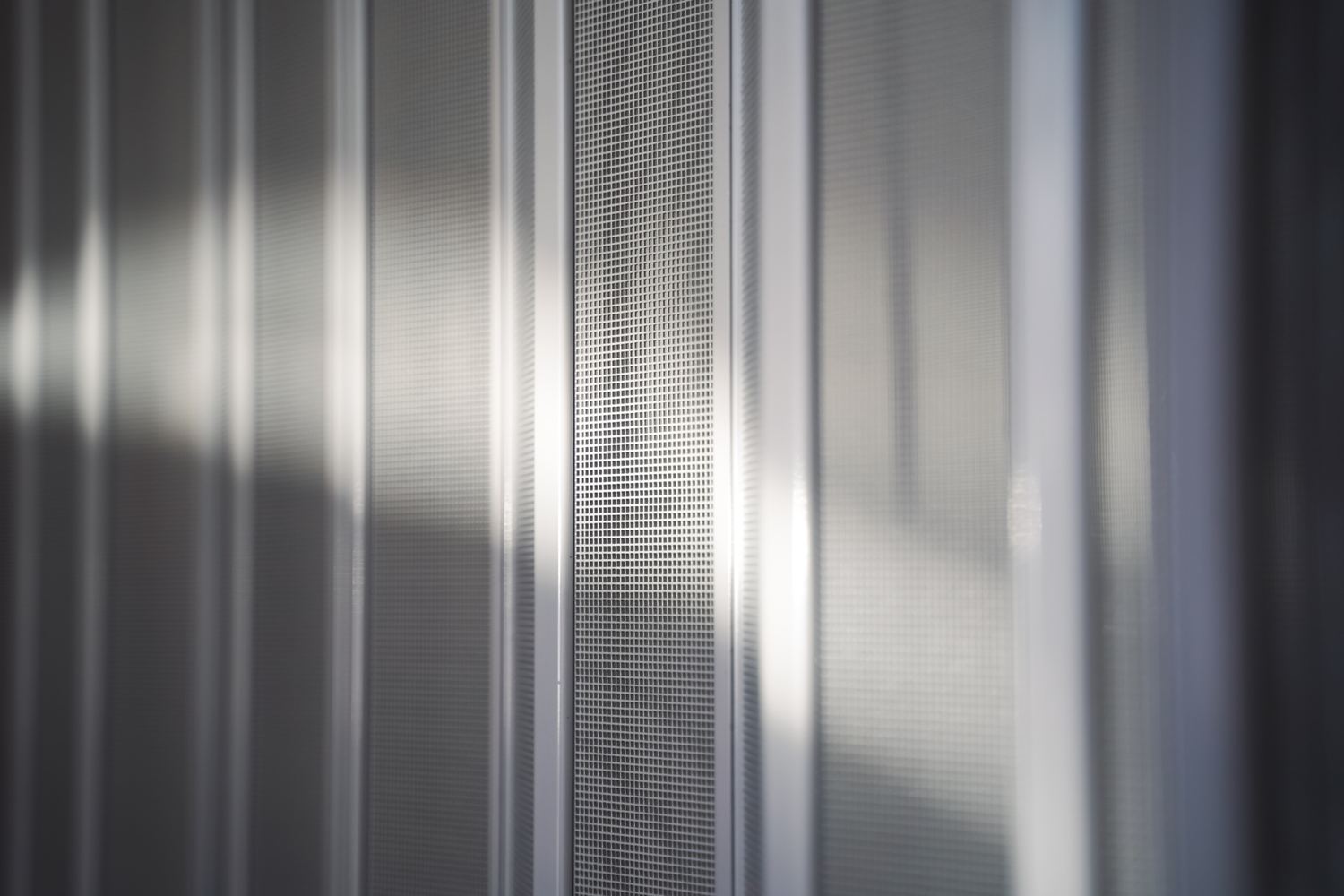 Close-up of the square-weave mesh between slim white panel strips